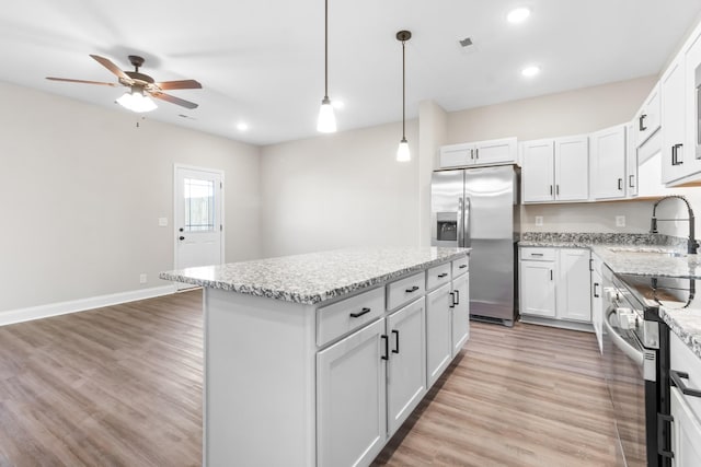 208 W Fallow Ct, Clarksville, TN 37040 - kitchen with stainless steel appliances, a center island, ceiling fan, light wood-style flooring, and light stone counters