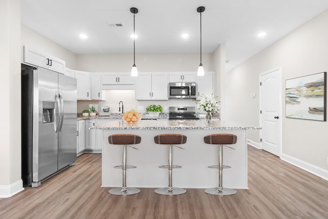 208 W Fallow Ct, Clarksville, TN 37040 - kitchen with appliances with stainless steel finishes, light wood-style floors, light stone counters, a kitchen bar, and recessed lighting