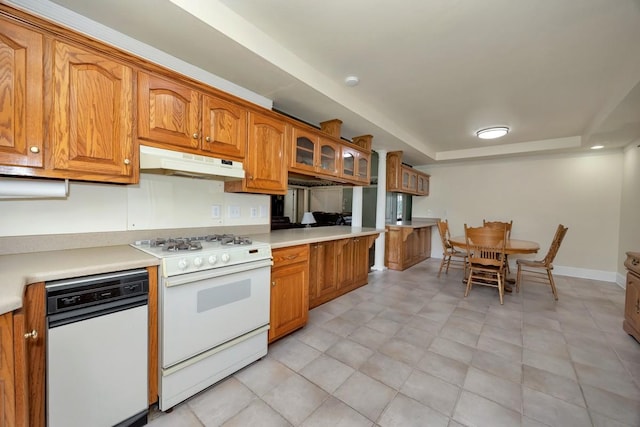 27615 Shannon Rd, Ardmore, AL 35739 - kitchen with under cabinet range hood, white range with gas cooktop, brown cabinetry, a raised ceiling, and light countertops