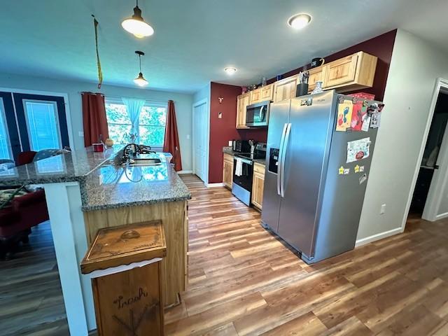2082 Airport Ridge Rd, Linden, TN 37096 - kitchen featuring stainless steel appliances, light wood-type flooring, pendant lighting, a kitchen island, and a kitchen bar