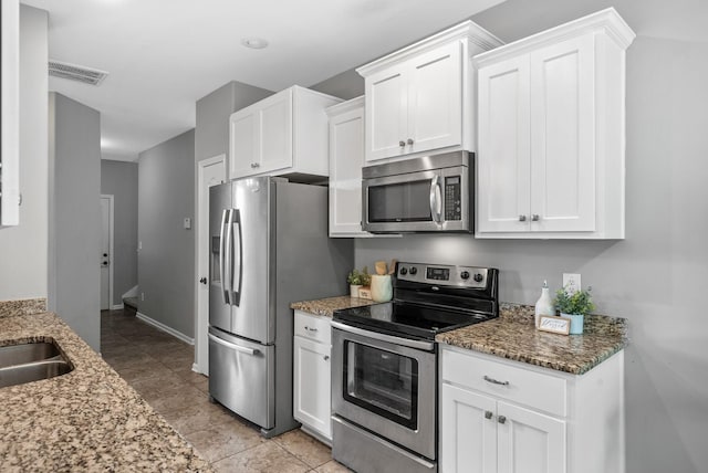 1398 Raven Rd, Clarksville, TN 37042 - kitchen featuring stainless steel appliances, white cabinets, light stone counters, and light tile patterned floors