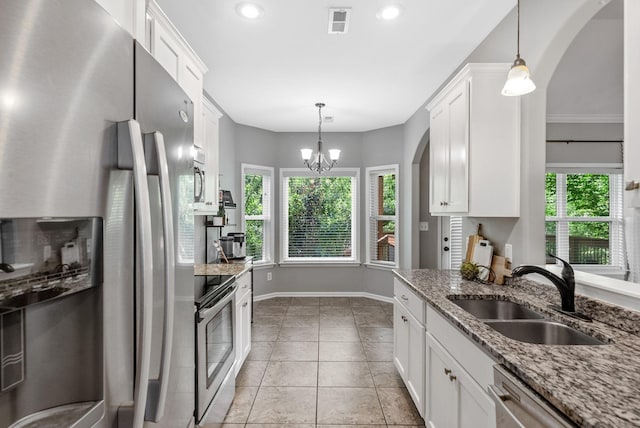 1398 Raven Rd, Clarksville, TN 37042 - kitchen featuring stainless steel appliances, white cabinets, arched walkways, light stone counters, and a chandelier