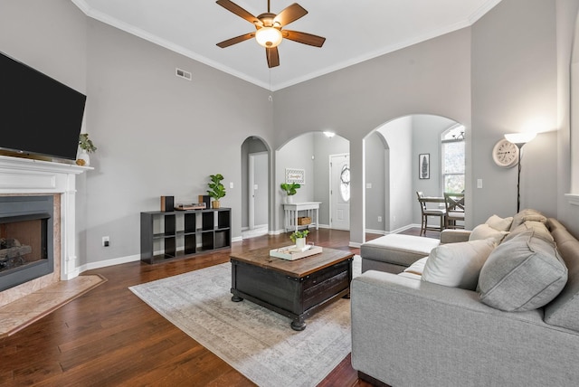 1398 Raven Rd, Clarksville, TN 37042 - living room featuring arched walkways, ceiling fan, wood finished floors, a towering ceiling, and a premium fireplace