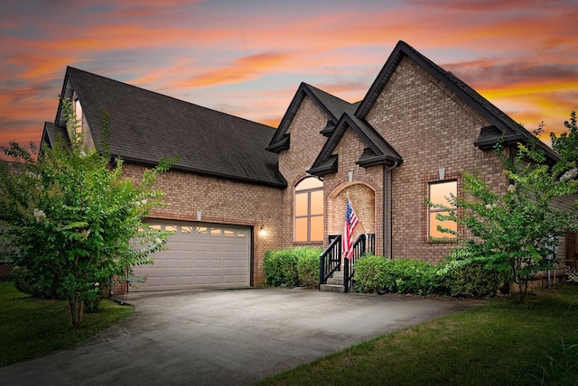1398 Raven Rd, Clarksville, TN 37042 - french country inspired facade featuring brick siding, driveway, roof with shingles, and an attached garage