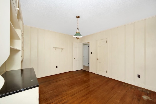 801 E Forrest St, Athens, AL 35611 - unfurnished dining area featuring dark wood-style floors and a decorative wall