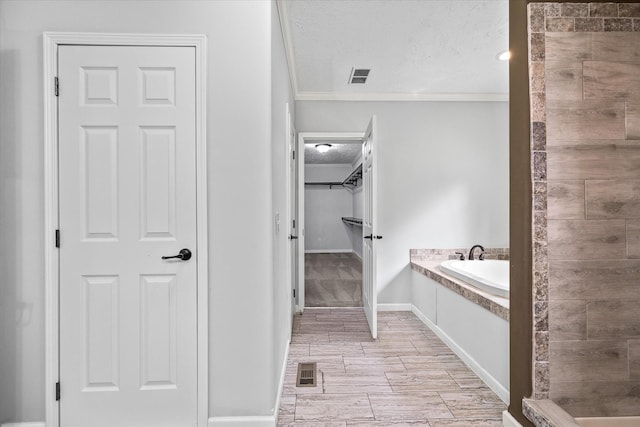 1901 Rickman Rd, Livingston, TN 38570 - bathroom featuring ornamental molding, a bath, a spacious closet, a textured ceiling, and tiled shower