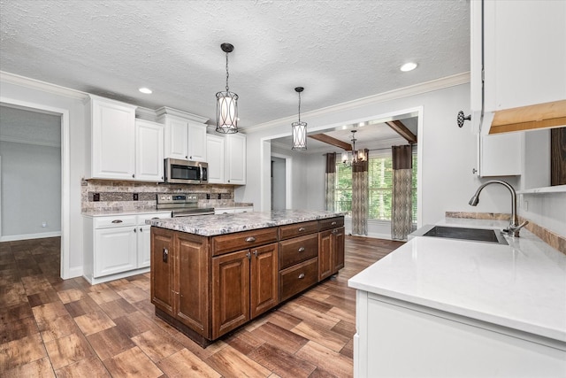 1901 Rickman Rd, Livingston, TN 38570 - kitchen featuring appliances with stainless steel finishes, crown molding, white cabinets, wood finished floors, and backsplash