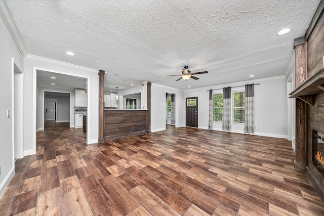 1901 Rickman Rd, Livingston, TN 38570 - unfurnished living room featuring a fireplace, a ceiling fan, dark wood-style flooring, decorative columns, and a textured ceiling