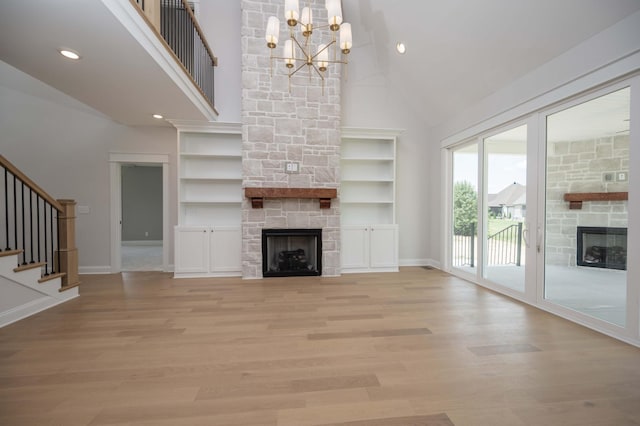 5077B Florence Rd, Murfreesboro, TN 37129 - unfurnished living room with a stone fireplace, high vaulted ceiling, a chandelier, light wood finished floors, and stairway