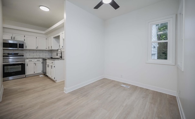 4037 Calumet Dr, Antioch, TN 37013 - kitchen with stainless steel appliances, white cabinets, light wood-style floors, and tasteful backsplash