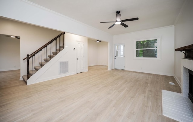 4037 Calumet Dr, Antioch, TN 37013 - unfurnished living room featuring a ceiling fan, stairs, a brick fireplace, ornamental molding, and light wood-style flooring