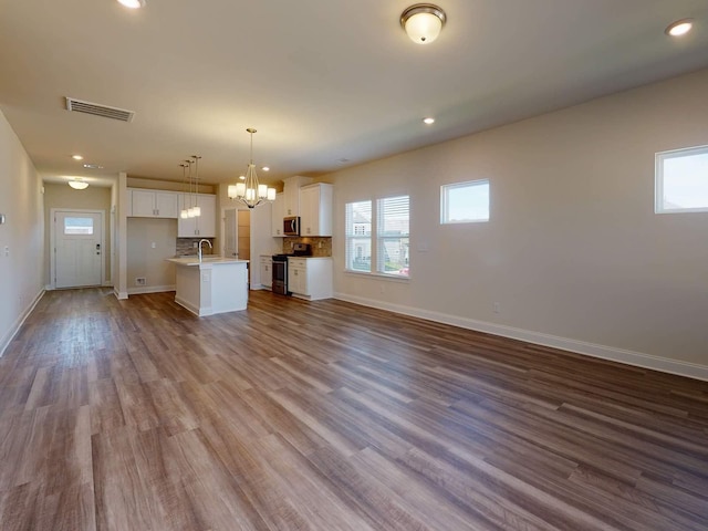 1334 Beasley Blvd, Mount Juliet, TN 37122 - unfurnished living room featuring a chandelier, plenty of natural light, dark wood finished floors, and recessed lighting