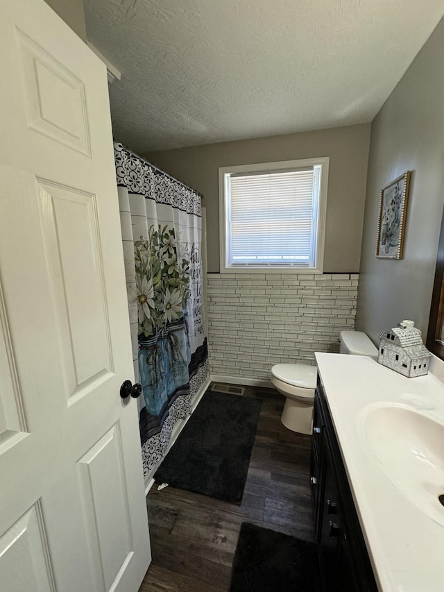 1304 Ellington Dr, Lafayette, TN 37083 - bathroom featuring wood finished floors, vanity, tile walls, a textured ceiling, and wainscoting