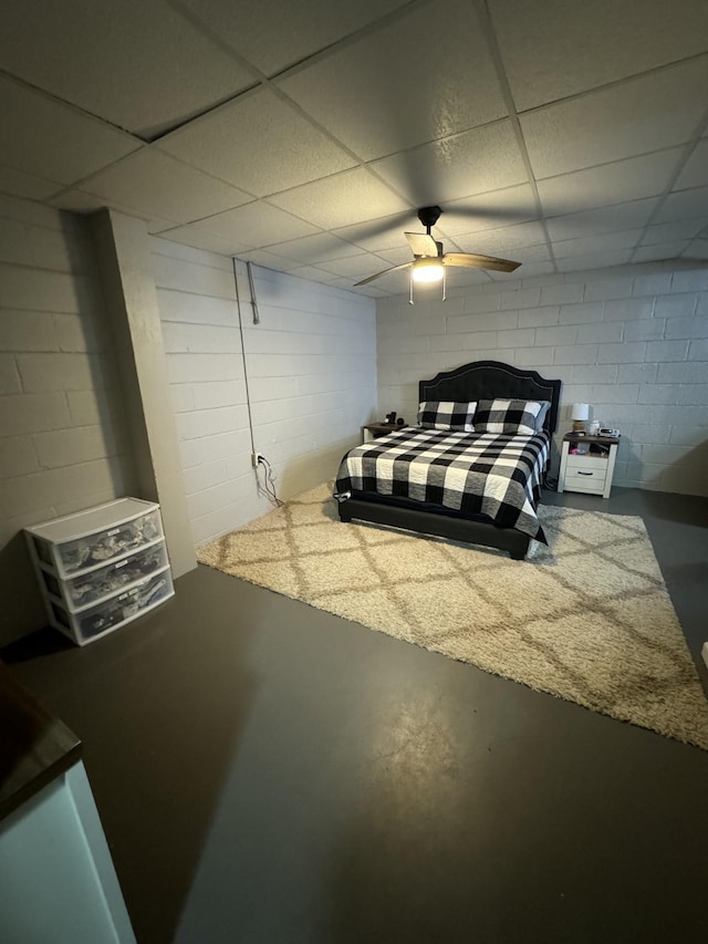 1304 Ellington Dr, Lafayette, TN 37083 - bedroom featuring finished concrete floors, concrete block wall, a drop ceiling, and ceiling fan