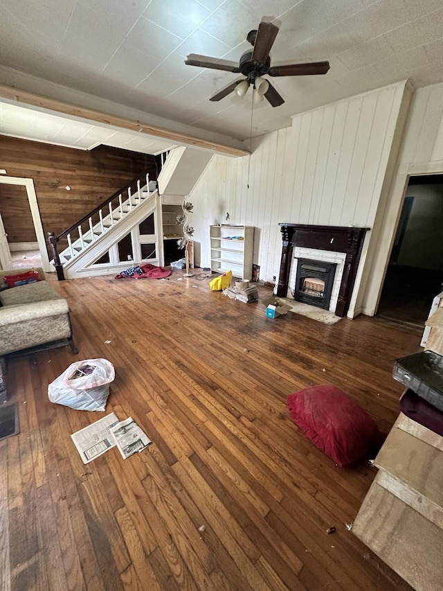 112 W Hackberry St, Centerville, TN 37033 - living area featuring wooden walls, a fireplace with flush hearth, stairs, hardwood / wood-style floors, and ceiling fan