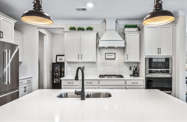 141 Foxhall Dr, Spring Hill, TN 37174 - kitchen with appliances with stainless steel finishes, custom exhaust hood, backsplash, light countertops, and beverage cooler
