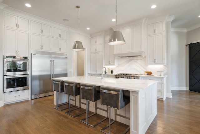 7521 Whiskey Rd, College Grove, TN 37046 - kitchen featuring stainless steel appliances, white cabinets, a barn door, tasteful backsplash, and crown molding
