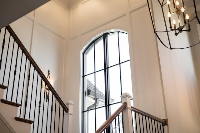 7521 Whiskey Rd, College Grove, TN 37046 - stairs featuring healthy amount of natural light, a chandelier, a decorative wall, and a towering ceiling