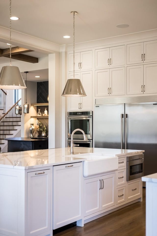 7521 Whiskey Rd, College Grove, TN 37046 - kitchen featuring double oven, light stone countertops, white cabinetry, beamed ceiling, and dark wood-style flooring