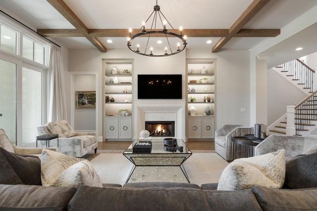 7521 Whiskey Rd, College Grove, TN 37046 - living room featuring coffered ceiling, a lit fireplace, stairs, light wood-style flooring, and a chandelier