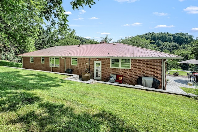 330 Cascade Hollow Rd, Normandy, TN 37360 - rear view of house featuring a patio, a yard, a metal roof, brick siding, and a chimney