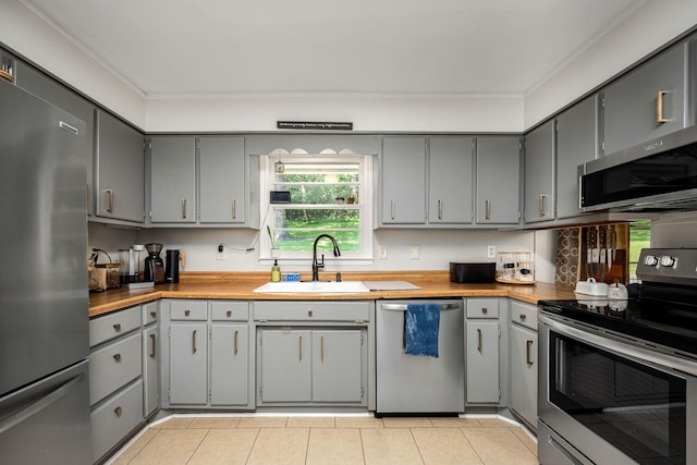 330 Cascade Hollow Rd, Normandy, TN 37360 - kitchen featuring appliances with stainless steel finishes, gray cabinets, light tile patterned floors, and ornamental molding