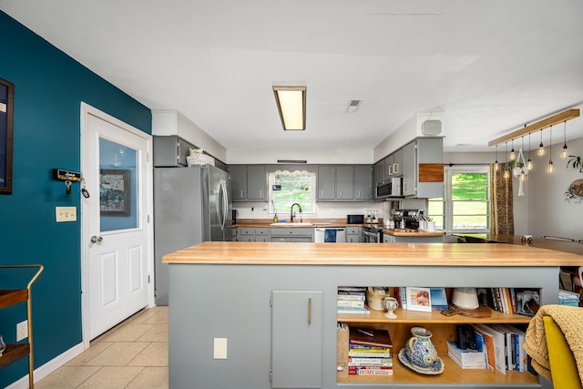 330 Cascade Hollow Rd, Normandy, TN 37360 - kitchen featuring appliances with stainless steel finishes, gray cabinetry, plenty of natural light, and light tile patterned floors