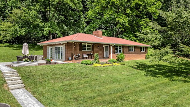 330 Cascade Hollow Rd, Normandy, TN 37360 - ranch-style home featuring brick siding, a chimney, a front yard, a metal roof, and a patio area