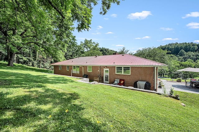 330 Cascade Hollow Rd, Normandy, TN 37360 - rear view of property featuring a patio area, a lawn, brick siding, and a metal roof