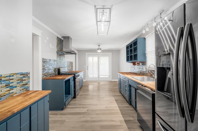 4052 Port Cleburne Ln, Hermitage, TN 37076 - kitchen featuring appliances with stainless steel finishes, butcher block counters, exhaust hood, blue cabinetry, and backsplash