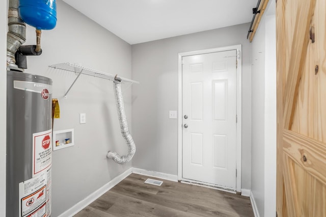 4052 Port Cleburne Ln, Hermitage, TN 37076 - washroom featuring gas water heater, dark wood-style flooring, washer hookup, and a barn door