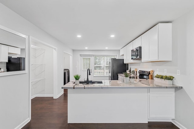 758 Spees Dr, Clarksville, TN 37042 - kitchen with appliances with stainless steel finishes, dark wood finished floors, white cabinets, a peninsula, and recessed lighting