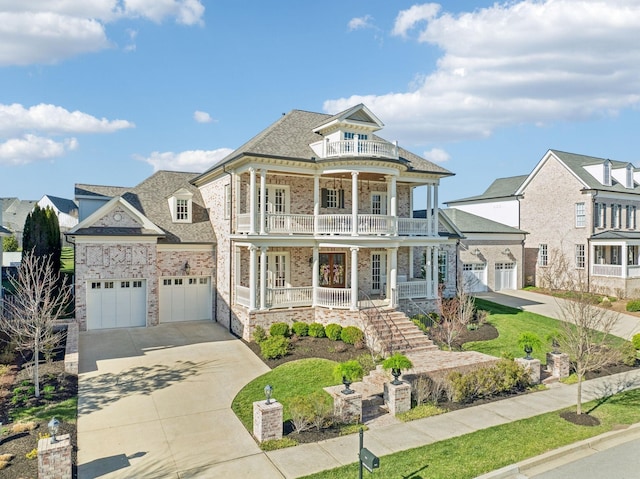 813 Stonewater Blvd, Franklin, TN 37064 - view of front of home featuring a balcony, a porch, concrete driveway, stone siding, and brick siding
