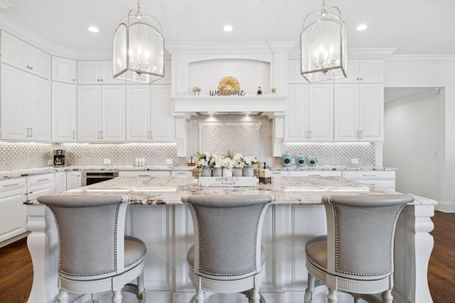 813 Stonewater Blvd, Franklin, TN 37064 - kitchen with a chandelier, white cabinetry, dark wood-style flooring, a center island, and decorative backsplash