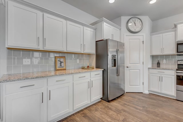 4112 Cadence Dr, Spring Hill, TN 37174 - kitchen with appliances with stainless steel finishes, white cabinets, tasteful backsplash, light wood-style flooring, and recessed lighting