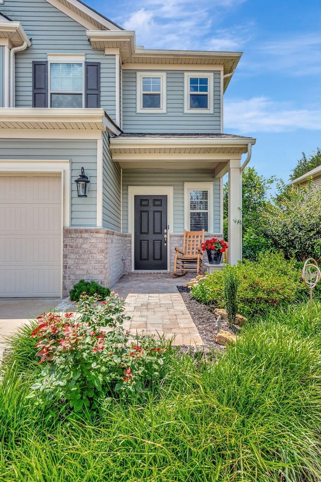 4112 Cadence Dr, Spring Hill, TN 37174 - entrance to property featuring covered porch, brick siding, and an attached garage