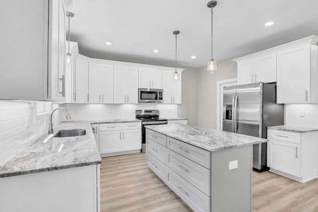 582 Pongracz Way, Clarksville, TN 37042 - kitchen with appliances with stainless steel finishes, decorative backsplash, a center island, light wood-style flooring, and recessed lighting