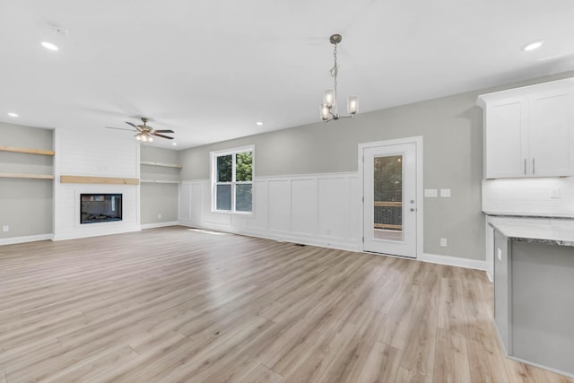 582 Pongracz Way, Clarksville, TN 37042 - unfurnished living room with ceiling fan, light wood-type flooring, a large fireplace, recessed lighting, and built in shelves