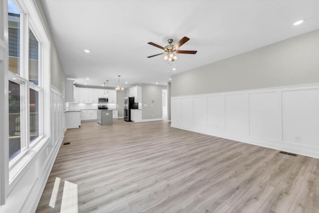 582 Pongracz Way, Clarksville, TN 37042 - unfurnished living room with ceiling fan, recessed lighting, a decorative wall, light wood-style flooring, and wainscoting