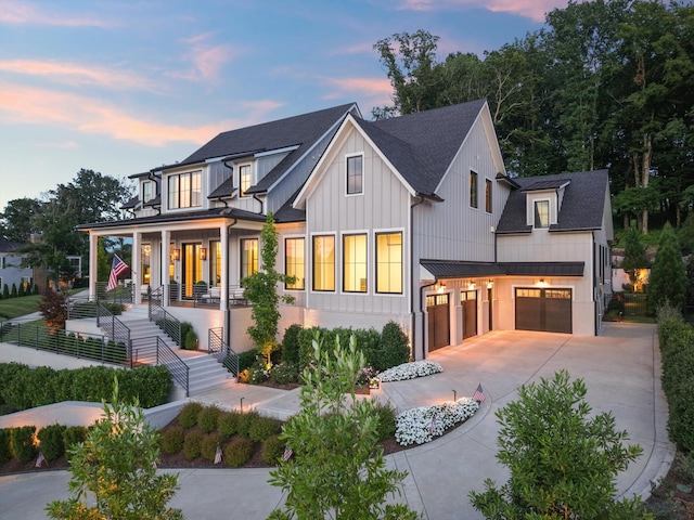 8227 Heirloom Blvd, College Grove, TN 37046 - modern farmhouse style home featuring an attached garage, covered porch, board and batten siding, concrete driveway, and a standing seam roof