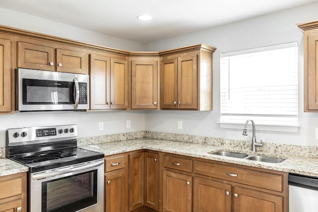 2075 Downstream Dr, Ashland City, TN 37015 - kitchen featuring appliances with stainless steel finishes, brown cabinets, and light stone countertops