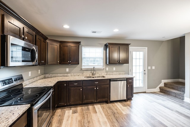 2071 Downstream Dr, Ashland City, TN 37015 - kitchen with stainless steel appliances, dark brown cabinets, light wood-style floors, light stone countertops, and recessed lighting