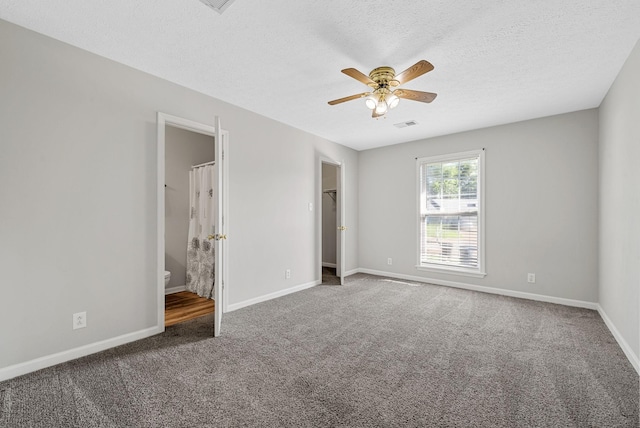 1066 Shadow Ridge Ave, Oak Grove, KY 42262 - unfurnished bedroom featuring carpet floors, a walk in closet, a textured ceiling, connected bathroom, and ceiling fan