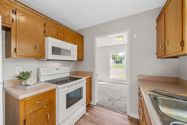 1066 Shadow Ridge Ave, Oak Grove, KY 42262 - kitchen featuring white appliances, light wood-type flooring, light countertops, and brown cabinetry