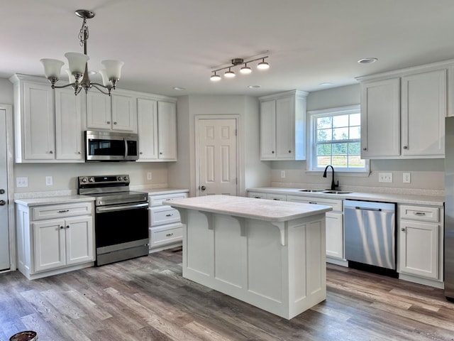 1122 Brannon Rd, Lawrenceburg, TN 38464 - kitchen featuring stainless steel appliances, light countertops, white cabinets, a chandelier, and a center island