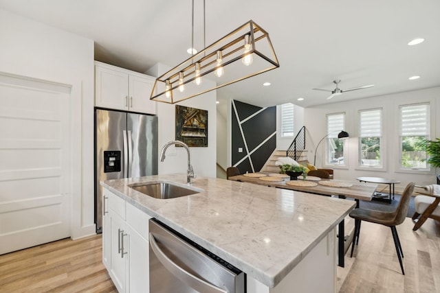 1111 Baptist World Center Dr Unit 5, Nashville, TN 37207 - kitchen featuring stainless steel appliances, light wood-style flooring, white cabinets, ceiling fan, and pendant lighting