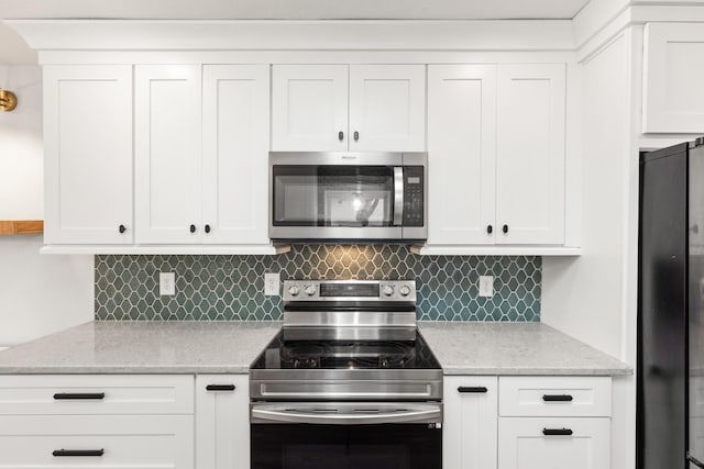 8205 Brownstone Ext, Cross Plains, TN 37049 - kitchen featuring stainless steel appliances, tasteful backsplash, white cabinets, and light stone countertops