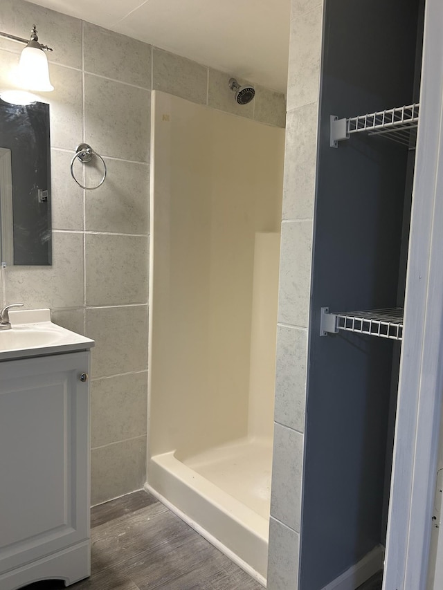716 Muskhogean Ct, Antioch, TN 37013 - bathroom featuring a shower, wood finished floors, vanity, and tile walls