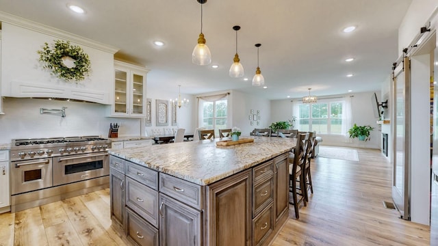 548 Buddy Rd, Burns, TN 37029 - kitchen featuring range with two ovens, a barn door, a breakfast bar area, light wood-type flooring, and recessed lighting