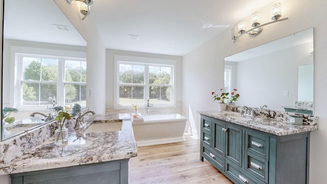 548 Buddy Rd, Burns, TN 37029 - bathroom featuring vanity, a freestanding tub, and wood finished floors